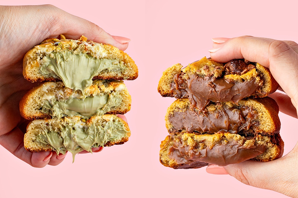 Duas mãos segurando cookies recheados abertos ao meio